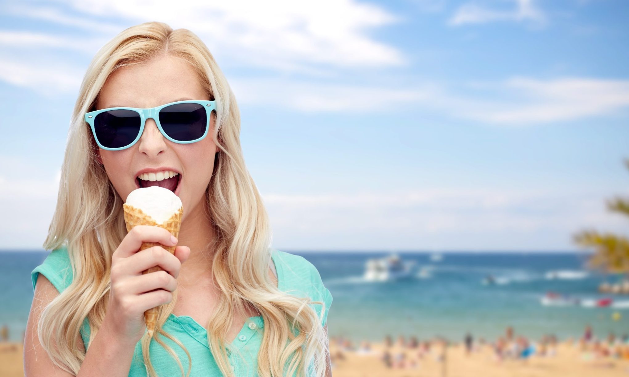 happy-young-woman-in-sunglasses-eating-ice-cream